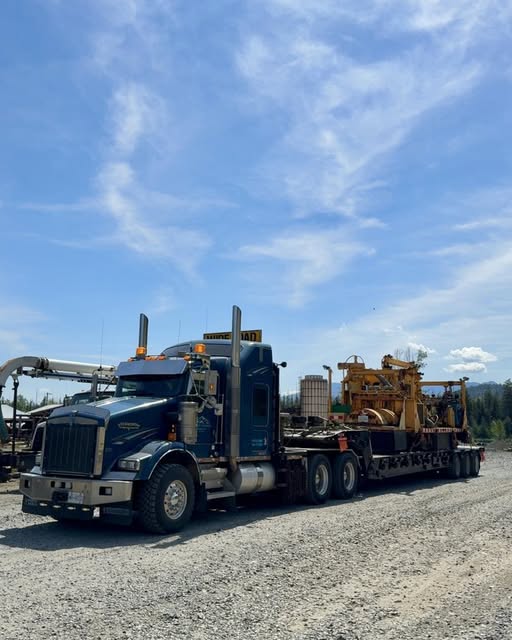 Altitude Transport Kenworth T800 winch truck hauling rail equipment under blue sky